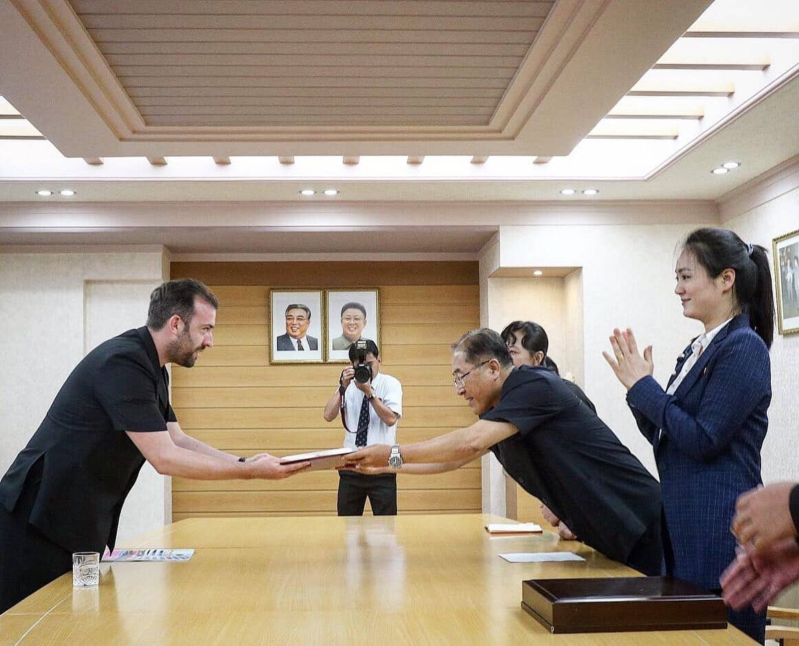 Shane Horan, founder of Rocky Road Travel receiving the pin of North Korean leaders