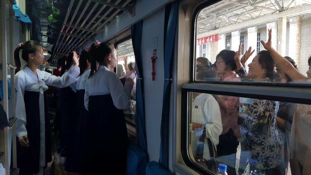 Can north koreans travel? North Korean girls waving goodbye at Pyongyang station on their way to China