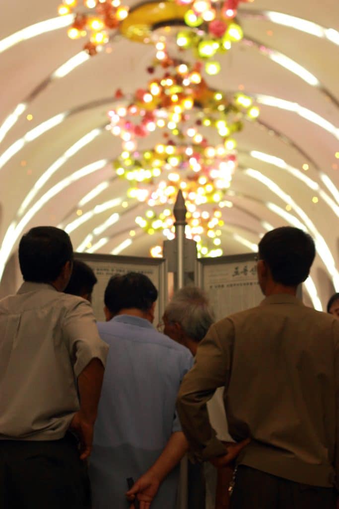North koreans read the Rodong sinmun on the Pyongyang metro